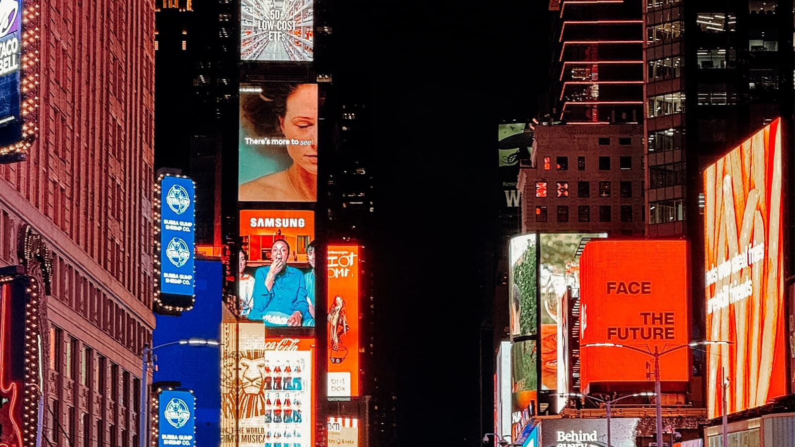 Las pantallas de Times Square encendidas de noche, todas compitiendo entre sí