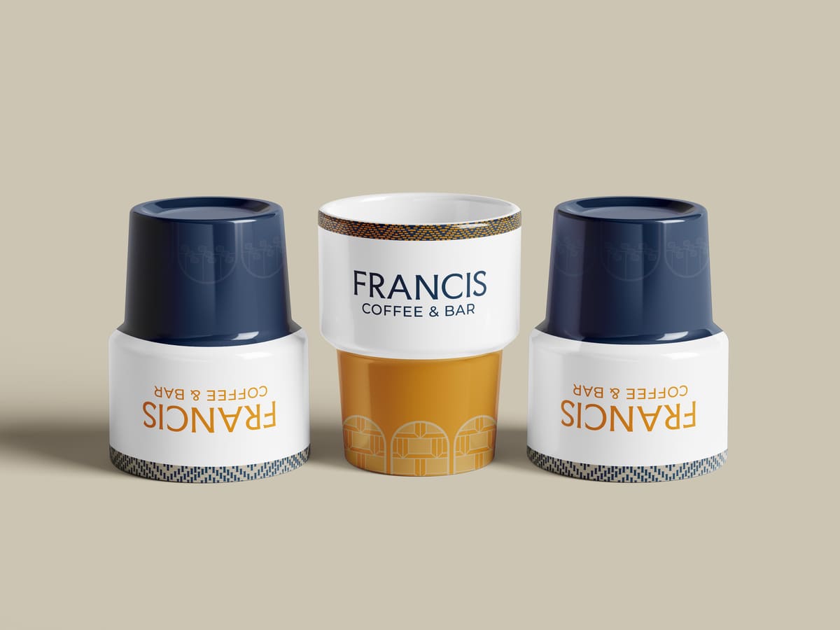 Tazas de Francis Coffee & Bar en azul, blanco y dorado, con el patrón de la silla en el borde