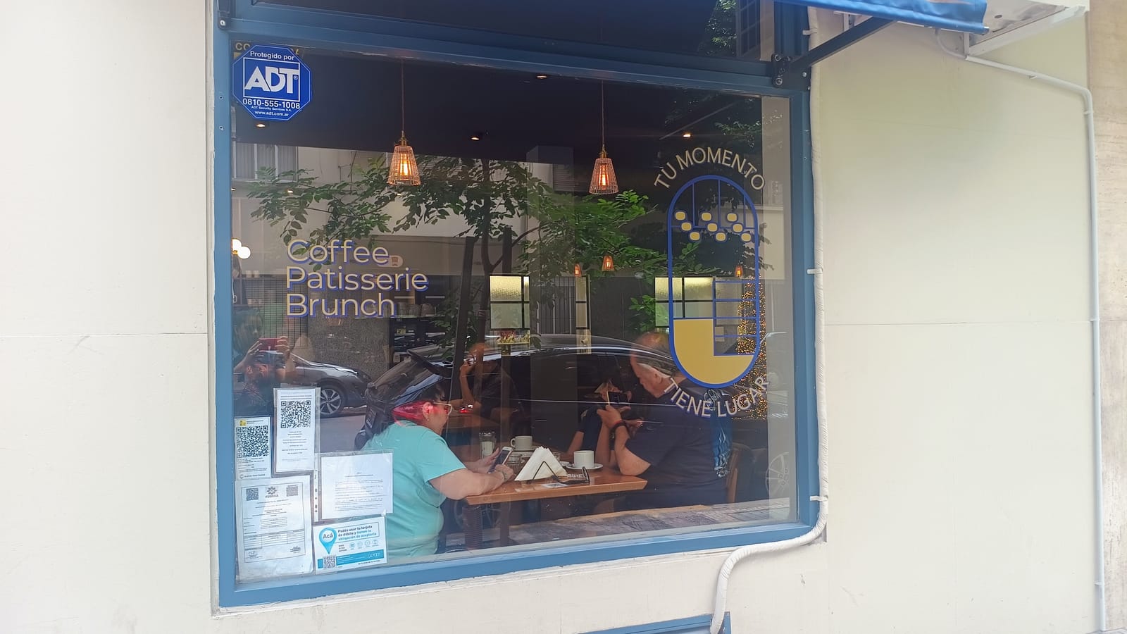 Vidriera de Francis con los descriptores Coffee, Patisserie y Brunch y el eslogan «Tu momento tiene lugar» en vinilo dorado