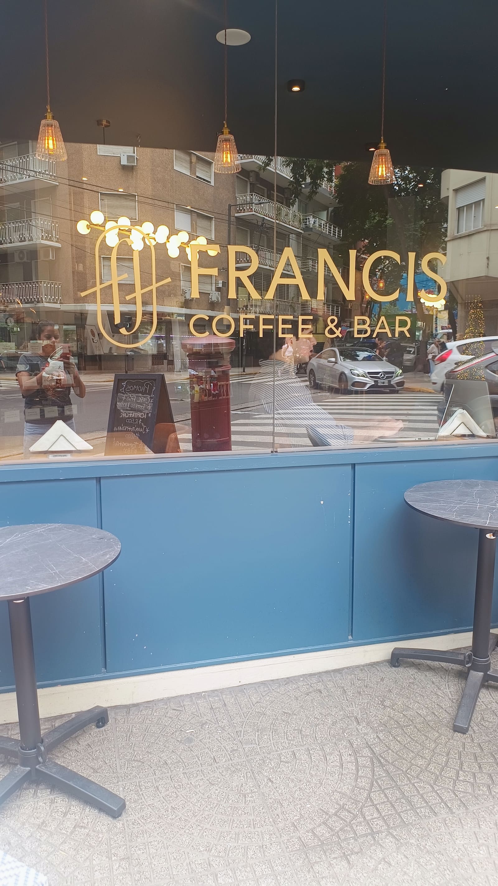 Vidriera de Francis con el imagotipo en vinilo dorado, vista desde la vereda