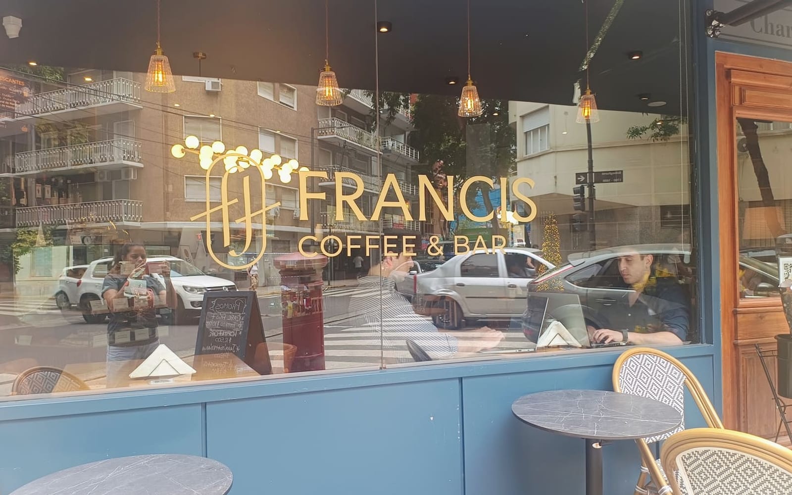 Vidriera de Francis Coffee & Bar con el imagotipo en vinilo dorado sobre el vidrio